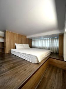 a large bed in a room with wooden floors at Era Apartment Đông Tác in Hanoi