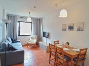 een woonkamer met een tafel en een blauwe bank bij Estudio venus in Sierra Nevada