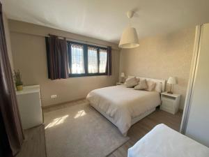 ein Schlafzimmer mit einem weißen Bett und einem Fenster in der Unterkunft Casa en Montealegre reformada y acogedora (wifi) in Sámano