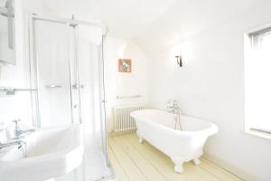 a white bathroom with a tub and a sink at Tiger Villa, Aldeburgh in Aldeburgh