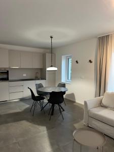 a kitchen and a living room with a table and chairs at Apartments Lily in Ljubljana