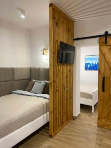 a bedroom with a bed and a tv on a wall at Apartament La Playa! Najlepsza lokalizacja! in Hel