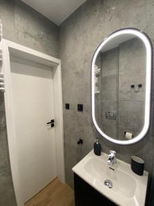 a bathroom with a sink and a mirror at Apartament La Playa! Najlepsza lokalizacja! in Hel