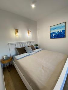 a white bedroom with a large bed in it at Apartament La Playa! Najlepsza lokalizacja! in Hel