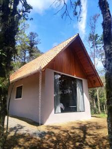 mały biały dom z dużym oknem w obiekcie Casa Kafka - Bio Cult w mieście Campo Alegre