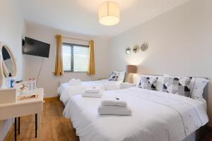 a bedroom with two beds with towels on them at Beach Lodge in Barna