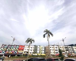 une rangée de bâtiments avec des palmiers au premier plan dans l'établissement Maco Inn Century @Johor Bahru, à Johor Bahru