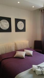 a bedroom with a bed with three moon pictures on the wall at B&B Il Ballatoio in Milan