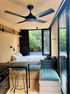 een slaapkamer met een bed en een plafondventilator bij aMiniMas Eco gîtes in Le Garn