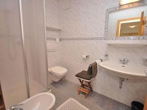 a white bathroom with a sink and a toilet at Im Kranzhof in San Candido