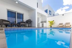 una piscina de agua azul en una casa en Villa Escondida #3 In the center of POP city, en San Felipe de Puerto Plata