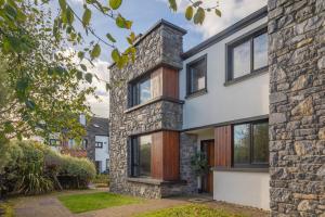 an exterior view of a house with a stone wall at Beach Lodge in Barna