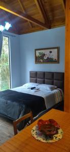 sypialnia z łóżkiem i stołem z talerzem w obiekcie Casa Kafka - Bio Cult w mieście Campo Alegre