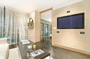 a living room with a large flat screen tv on a wall at Hi-End 2BR, 2BR Apt, Heart of Canary Wharf in London