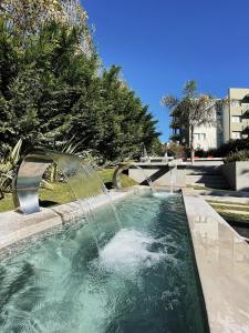 a pool with a water fountain in a yard at Aguas de Oro in Villa Gesell