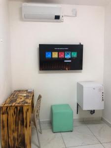 um quarto com uma mesa e uma televisão na parede em THEMATIC POUSADA em João Pessoa