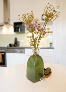 un vase avec des fleurs sur un comptoir dans une cuisine dans l'établissement Stilvolles Apartment in zentraler Lage, à Graz