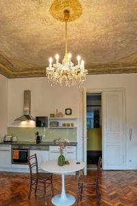 une cuisine avec une table et des chaises ainsi qu'un lustre dans l'établissement Stilvolles Apartment in zentraler Lage, à Graz