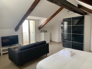 a living room with a couch and a television at Folle Città B&B in Naples