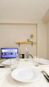 a white table with glasses and a laptop computer at Amanecer del Fuego III in Ushuaia