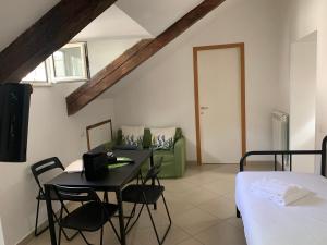 a living room with a table and a green couch at Folle Città B&B in Naples