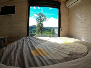 a large bed in a room with a window at Tiny House Birner Ertl in Ertl
