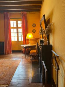 sala de estar con mesa, lámpara y paredes amarillas en Manoir de la Rémonière en Azay-le-Rideau