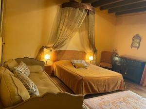 1 dormitorio con 2 camas y sofá en Manoir de la Rémonière en Azay-le-Rideau