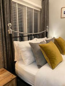 ein Schlafzimmer mit einem Bett mit Kissen und einem Fenster in der Unterkunft Mumbles - Modern Apartment with panoramic sea views in Oystermouth