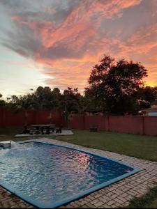 una piscina in un cortile con un tramonto di Holiday Villa Famosa a Malacca