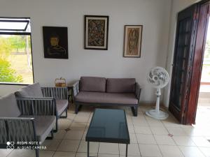 uma sala de estar com sofás, uma mesa e uma ventoinha em Conjunto vacacional Cocomar-Casa 6-4h em Carrizal