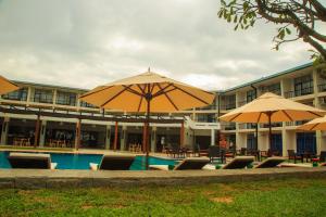 
a patio area with chairs and umbrellas at Camelot Beach Hotel in Negombo
