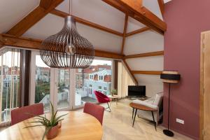 sala de estar con mesa de comedor y ventana grande en La Paulowna Boutique Hotel, en La Haya