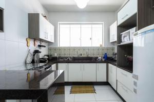 a kitchen with white cabinets and a large window at Casarão ESPAÇOSO a 800m do centro, pet friendly, 8 pessoas, garagem para 3 carros in Tiradentes