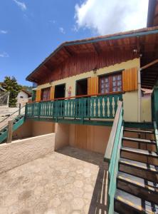 budynek z balkonem i schodami przed nim w obiekcie CHALES CARVALHOS w mieście Monte Verde