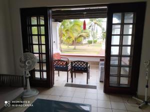 uma porta aberta para um pátio com cadeiras e uma ventoinha em Conjunto vacacional Cocomar-Casa 6-4h em Carrizal