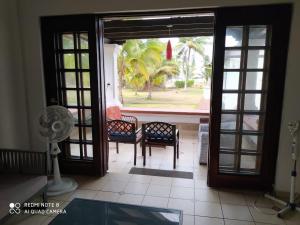 an open door to a patio with chairs and a fan at Conjunto vacacional Cocomar-Casa 6-4h in Carrizal