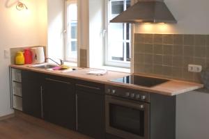 a kitchen with black cabinets and a sink and a window at Wohnen am Dehnthof Haus 2 in Kappeln