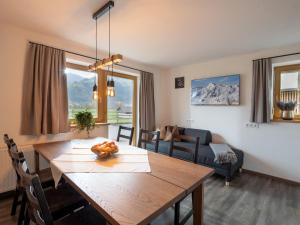 a dining room and living room with a wooden table at Zillertal Suites in Kaltenbach