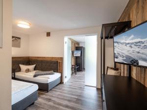 a bedroom with a bed and a flat screen tv at Zillertal Suites in Kaltenbach