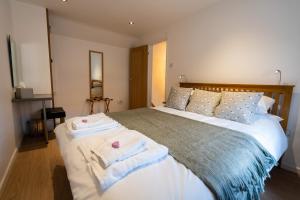 a bedroom with a bed with towels on it at Southwell Holiday Cottage - Lavender Cottage in Southwell