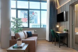 ein Wohnzimmer mit einem Sofa, einem Tisch und einem Fenster in der Unterkunft Alva Hotel in Reykjavík