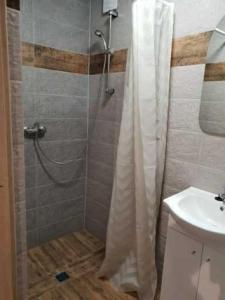 uma casa de banho com um chuveiro e um lavatório. em Noclegi u Dorki em Kurzetnik