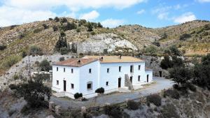 an aerial view of a white building on a hill at Casas Rurales Cortijo Leontino in Taberno