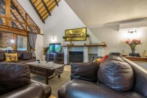 a living room with a leather couch and a table at Kruger Park Lodge Unit No. 221 in Hazyview