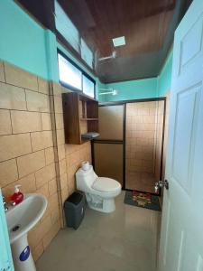 a small bathroom with a toilet and a sink at Encanto Arenal lodge in Fortuna