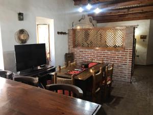 uma sala de jantar com uma mesa de madeira e uma televisão em Casa Quinta Chascomús em Chascomús