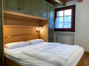 un grande letto in una camera da letto con finestra di Panorama Sozzine a Ponte di Legno