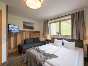 a hotel room with a bed and a couch at Zillertal Suites in Kaltenbach