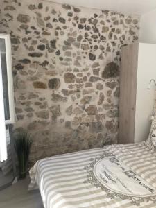 - une chambre avec un mur en pierre et un lit dans l'établissement Vieil Antibes, ravissant 2p avec petite terrasse, à Antibes